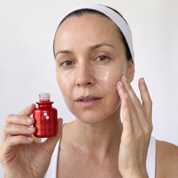 Woman holding 3LAB Daily Ampoule and pressing it into her cheek
