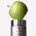 Dewy green Swiss apple resting on a jar of 3LAB "M" Cream, the source of its apple stem cell technology